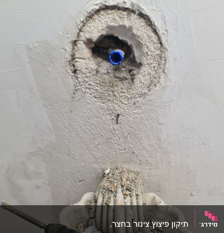 קיר עם חור וצינור כחול, מקדחה וכלי עבודה